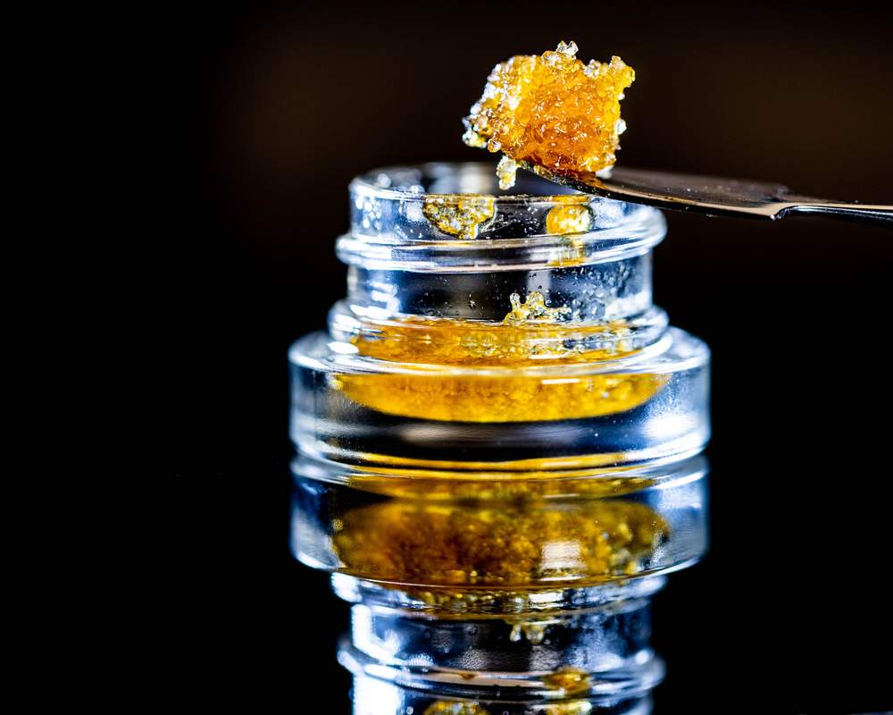 Concentré CBD premium de couleur ambrée présenté dans un récipient en verre pour illustration d'une extraction de CBD en Suisse.