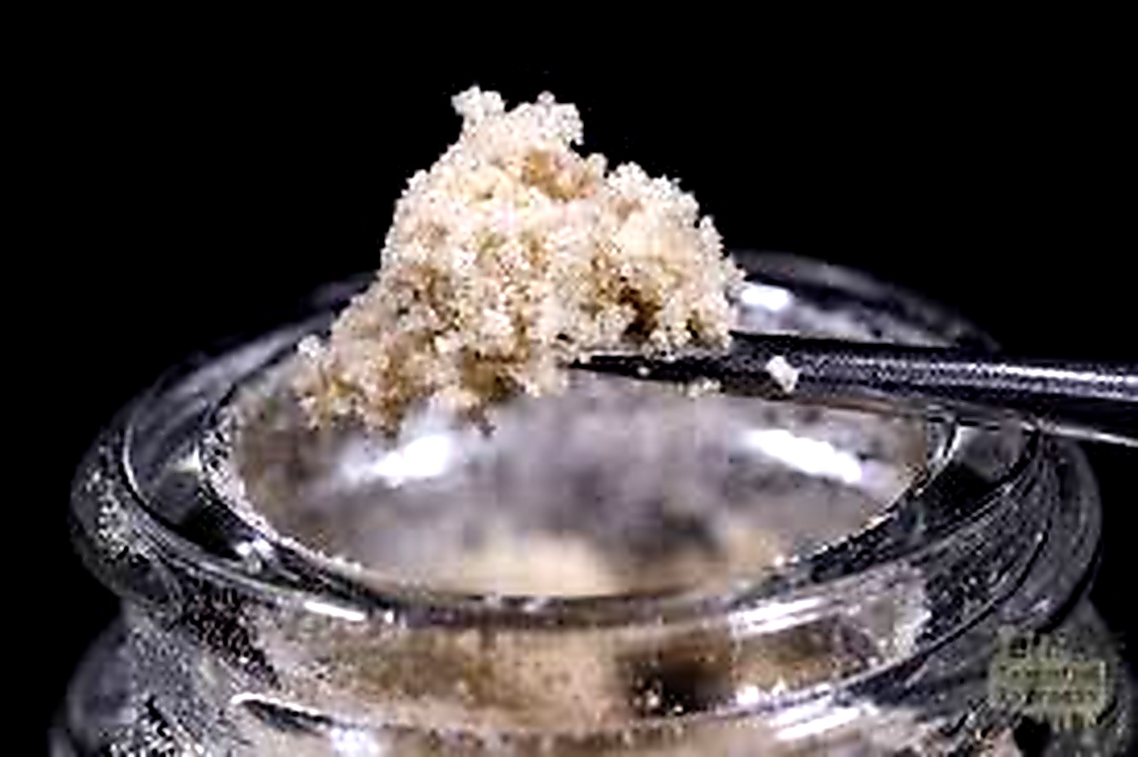 Dry sift hash composé de trichomes de cannabis tamisés montrant la texture sableuse caractéristique de la résine de cannabis concentrée.