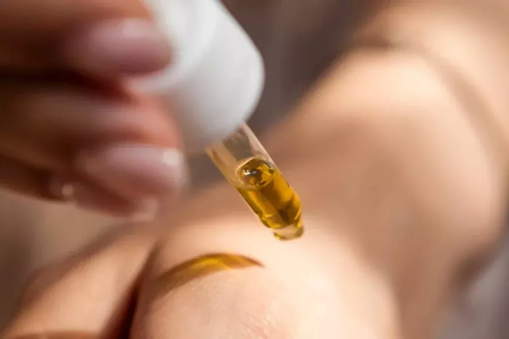 Goutte d’huile CBD appliquée sur la peau avec pipette à Genève Suisse