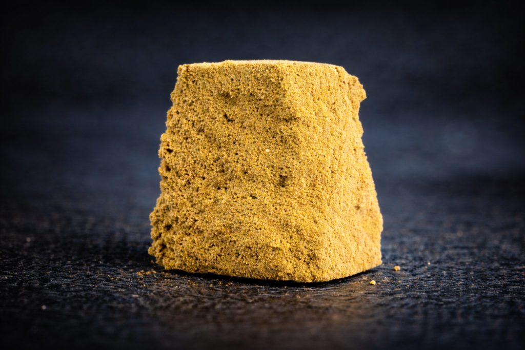 Pollen CBD jaune compressé riche en trichomes – résine cannabis CBD Genève guide hash 2026